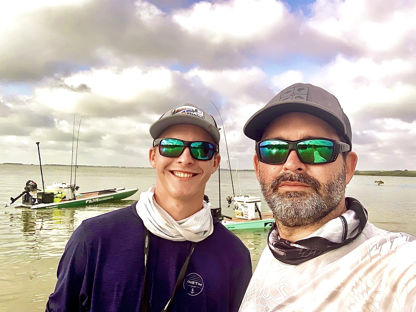 David and his son on the water, with two skiffs behind them