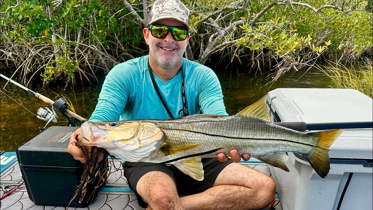 A happy customer holding a big snook caught from a SUP Customs rig